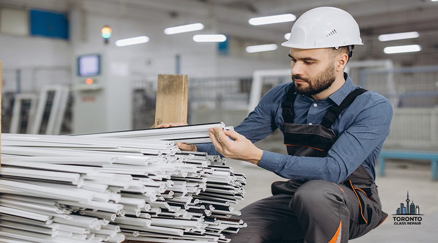 Factory worker inspecting the quality of PVC window profiles within a manufacturing plant, ensuring precision and craftsmanship in production