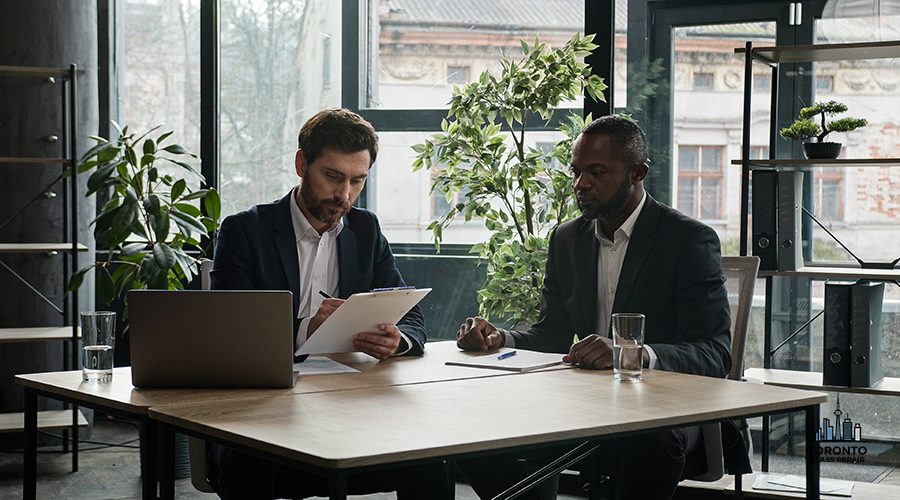 Multiethnic Caucasian and African American business people diverse multiracial men two male partners sitting at office desk sign document corporate paper successful partnership deal signing contract. High quality 4k footage