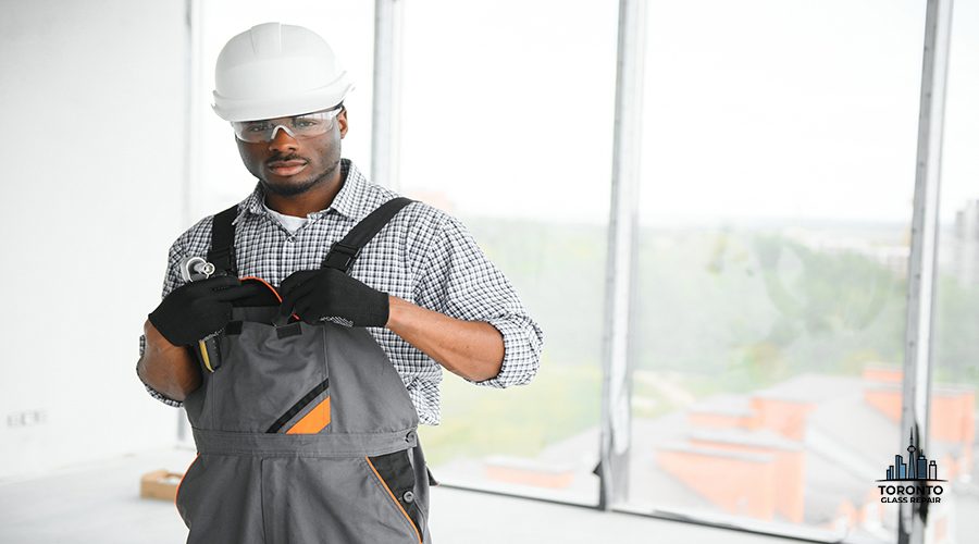 Portrait of handsome young african american male builder in hard hat, working at construction site.