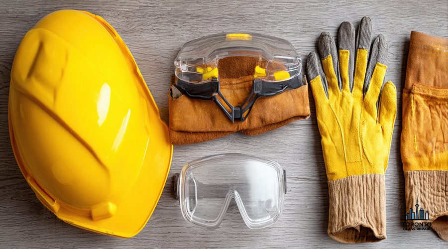 Hard hat, safety gloves, and goggles arranged flat on a neutral surface, showcasing essential protective equipment for construction work or industrial tasks.